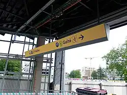 Signalétique directionnelle, sur fond jaune.