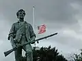 La statue devant le drapeau des États-Unis.