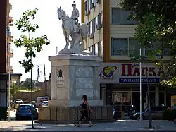 statue blanche d'un homme à cheval, au milieu d'une place