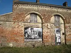Bâtiment en briques des années 1850 transformé en école. Sur les fenêtres, des photos de classe.