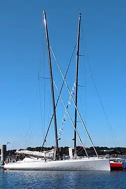 Vu de profil, en entier, bateau blanc amarré au ponton.