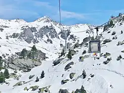Photographie de Plan-Bouchet avec une cabine devant, le paysage étant enneigé.