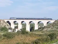 Près de la gare, un TER sur le viaduc de Lareraille en 2009.
