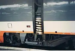 Sur le bas de caisse de la voiture TGV de gauche, on peut voir les deux voyants de contrôle du frein qui sont ici rouges donc serrés