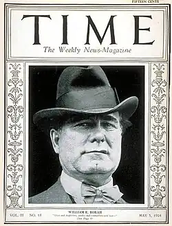 Couverture en noir et blanc d'un magazine comportant l'image du visage d'un homme portant un chapeau et un nœud papillon.