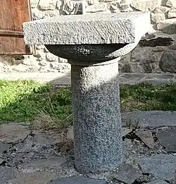 Table de messe en pierre taillée devant la chapelle de la Nativité de la Sainte-Vierge, aujourd'hui devenue une maison.
