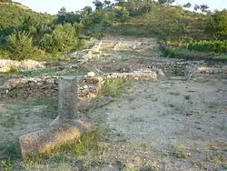 Photographie en couleur de ruines, des fondations de maison, en bord de colline