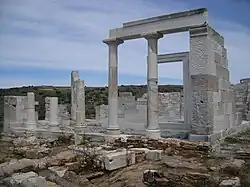photographie : un petit temple gris en ruines avec colonnes et architrave