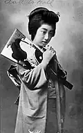 La geisha Teruha tenant un hagoita. Carte postale (1920)