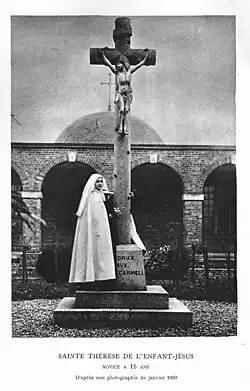 Thérèse de Lisieux devant une croix à écots