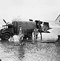 Des travailleurs civils déchargent le Douglas C-47 Dakota KP223 du 53 Squadron de la RAF.