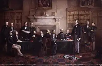 Peinture d'un groupe d'hommes en costume autour d'une table avec des bibliothèques et une imposante cheminée en marbre à l'arrière-plan.