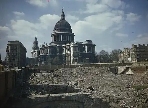 Vers la fin de la Seconde Guerre mondiale, vue de la cathédrale et, au premier plan, la jouxtant, un des secteurs de Londres qui ont été totalement détruits pendant le conflit (et dont la plupart des décombres ont vite été évacués). On constate que le monument semble avoir échappé de peu au même sort, ou du moins à des dommages bien plus importants que ceux qu'il a subi.