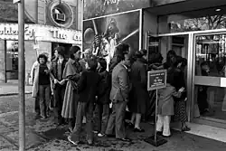 Du public attendant à l'entrée d'un cinéma.