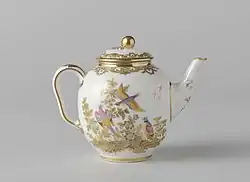 Une théière blanche au liseré doré et aux motifs fleuris.