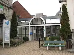 Photographie en couleurs de l'entrée d'un bâtiment, vue de face.