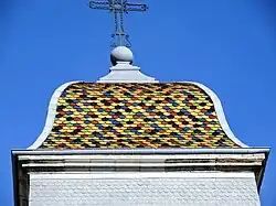 Couverture en tuiles écailles polychromes du clocher de l'église.