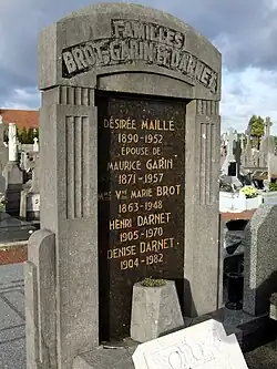 Photographie d'un monument funéraire en pierre grise et marbre noir.