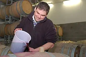 Ouillage avec un broc en plastique.