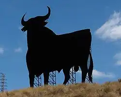 photo couleur se détachant sur un fond de ciel bleu, la silhouette noire découpé du taureau Osborne vue en perspective