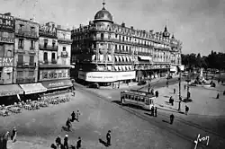 La Place de la Comédie peu avant la disparition des Tramways électriques de Montpellier. En provenance du Champ de Manœuvre, une motrice vestibulée et rénovée, de couleur jaune pâle, assure l'une des dernières circulations vers l'hôpital Saint-Eloi le 17 octobre 1947.