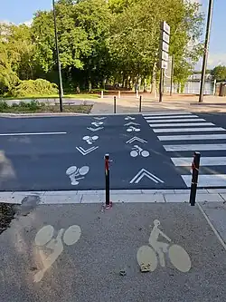 Traversée cycliste séparée du passage piétons en rive droite du pont avec marquages au sol non conformes