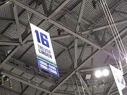Photographie couleur de la bannière numéro 16 accrochée sous le plafond de l'arena.