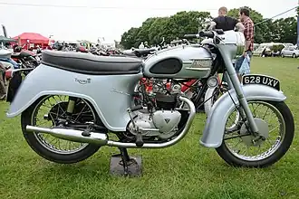 Triumph Twenty One avec pare-boue arrière « bathtub », nacelle d'optique intégrée, pots « saucisson », grips pour les genoux et porte-paquet sur le réservoir (1961).