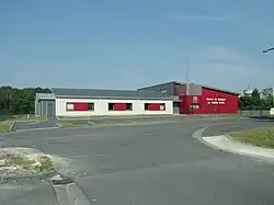 Photographie en couleurs de bâtiments et garages peints en blanc et rouge.