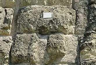 Photographie en couleurs d'un mur en gros blocs de peirre équarris.