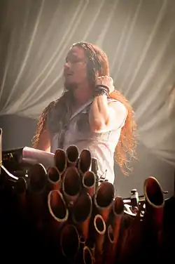 Image d'un homme brun se caressant les cheveux devant un clavier.