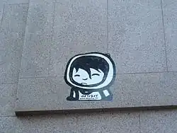 autocollant représentant un visage stylisé pris dans un écran de télévision, signé The tvboy