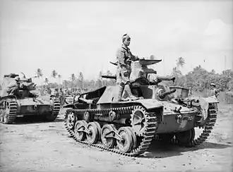 Photo en noir et blanc de deux chars de combat, un homme est debout sur le premier.