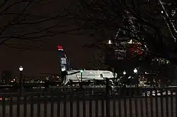 Photo de nuit montrant l'avion, aux couleurs bleues et blanches, sur la berge.
