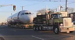 Photo de devant montrant le corps de l'avion tiré par un camion pour être déplacé vers un musée.