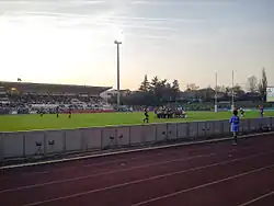 Deux groupes de joueurs de rugby entrent en mêlée sur la pelouse d'un stade.