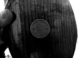 Une poulie du trois-mâts Belem, avec en son centre une ancienne pièce de cinq francs.