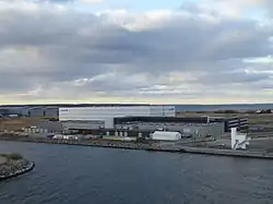 Hangar logistique blanc situé dans une zone portuaire.