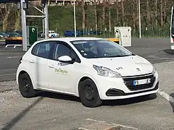 Photographie en couleurs représentant une voiture blanche.