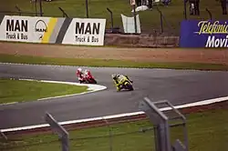 moto de Jeremy McWilliams dans un virage à gauche à la poursuite d'un autre concurrent