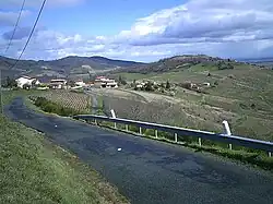 En arrière le hameau de Chamfray  (474&nbsp;m) sur la route D49 et la butte de la Madone (505&nbsp;m)  de Vaux-en-Beaujolais.