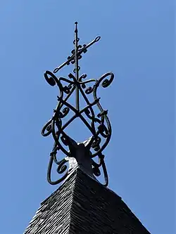 La croix sommitale de son clocher.