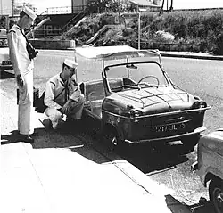 Photographie en noir et blanc d'une voiture de plage avec deux hommes