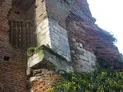 colonnes et morceaux de mur en pierre inclus dans une construction plus récente en brique foraine.