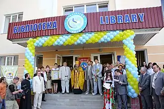 Entrée d'un bâtiment de style moderne, théâtre d'un rassemblement de personnes.