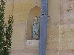 Une statue de la Vierge sur une façade de maison.
