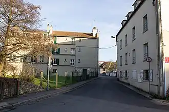 Vue d'une rue entre de petits immeubles.