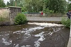 Vue d'une rivière en crue et d'un pont routier bientôt inondé.