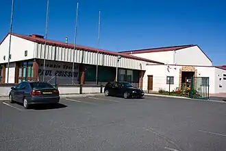  Vue d'un bâtiment allongé ; inscription sur le mur : « Ensemble sportif Paul Poisson ».