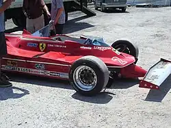 Photo d'une Ferrari 312 T5 dans un stand.
